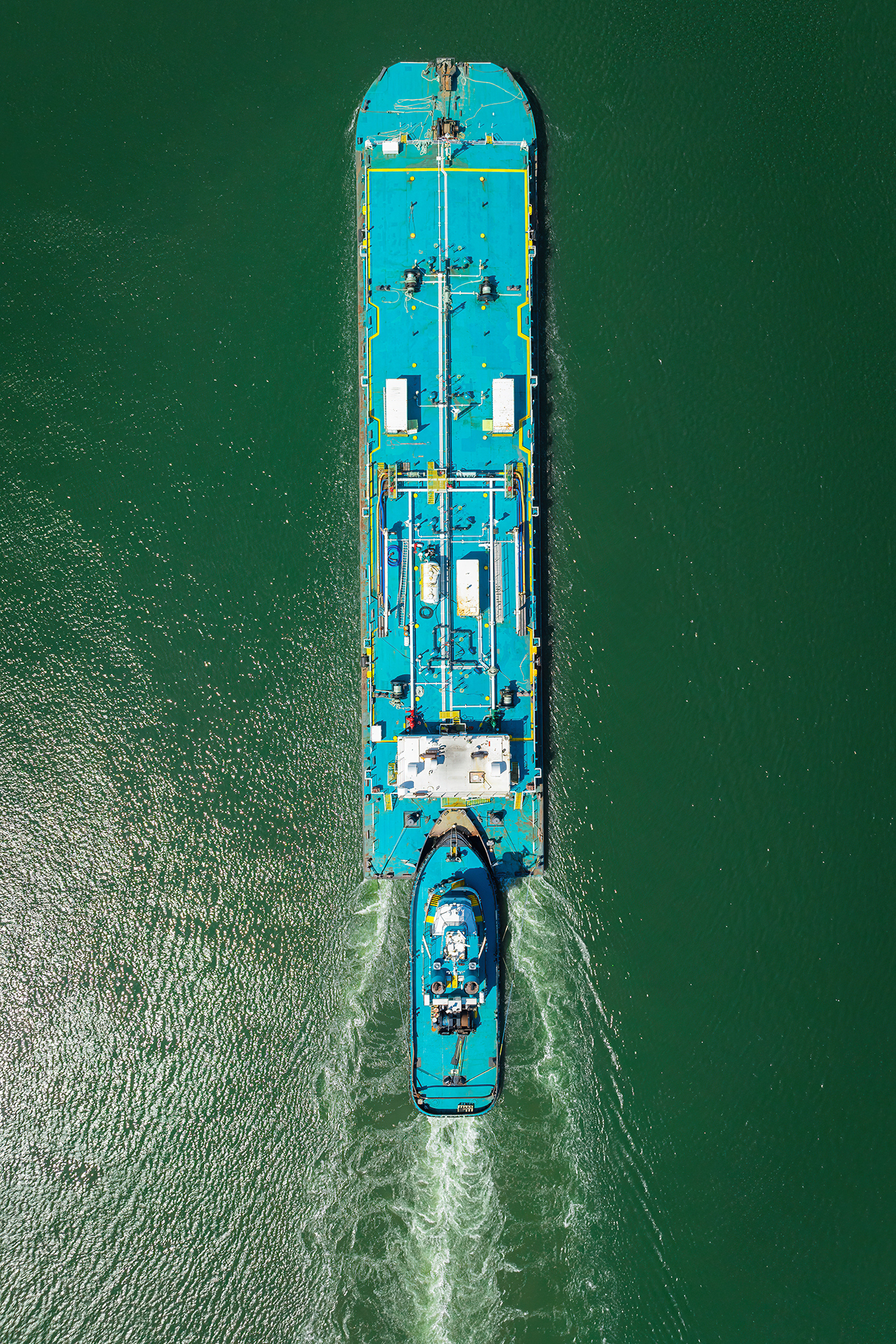 Drone Photograph Nadir angle of a Turquoise blue barge going up the Arthur Kill Waterway in New Jersey