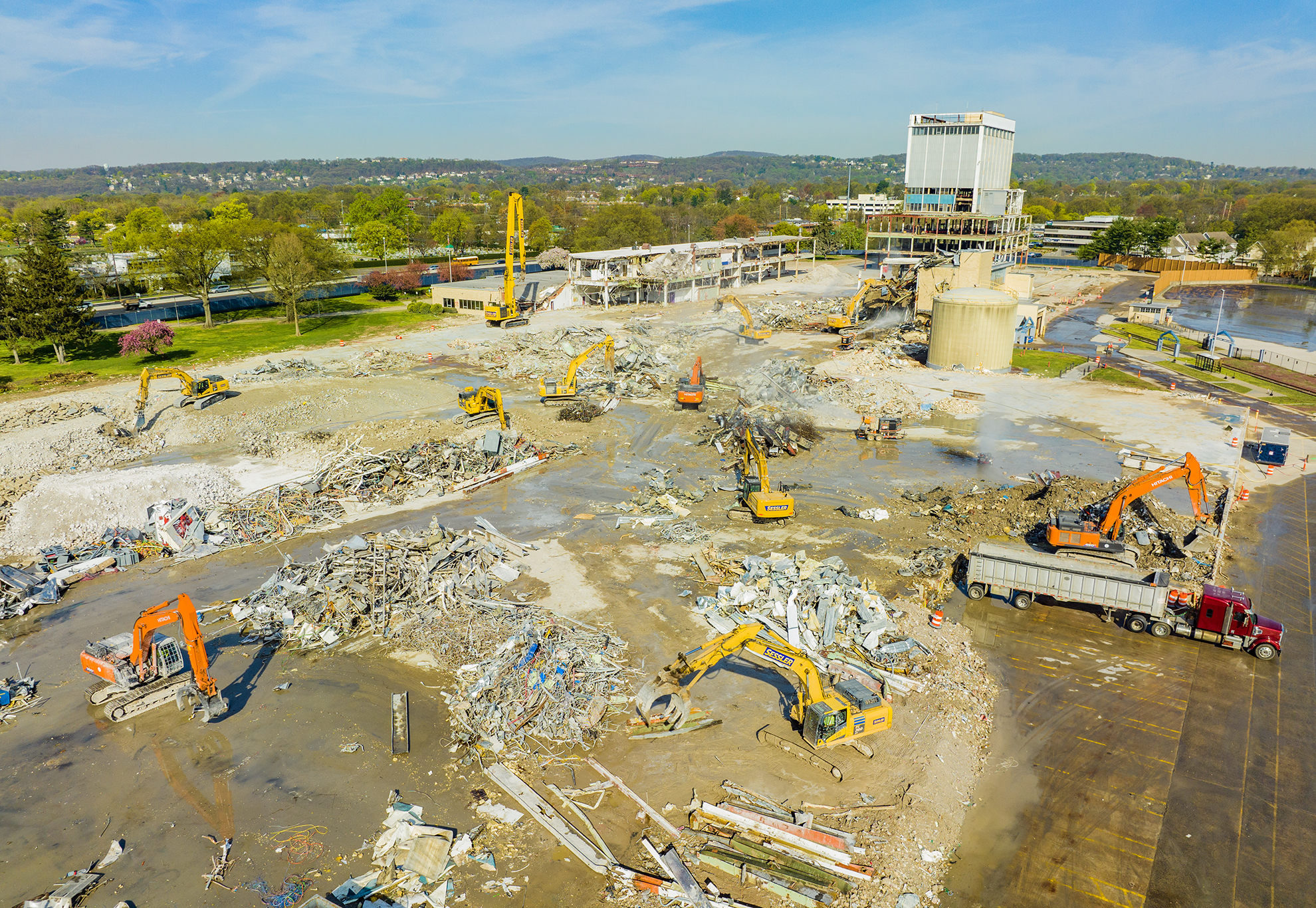 Drone photo of several excavators demolishing a building on a construction site